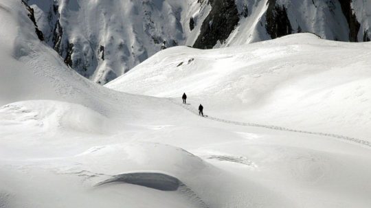 Na archívnej snímke z 11. apríla 2004 dvaja turisti kráčajú po snehu v masíve Formazza v regióne Piedmont v talianskych Alpách.