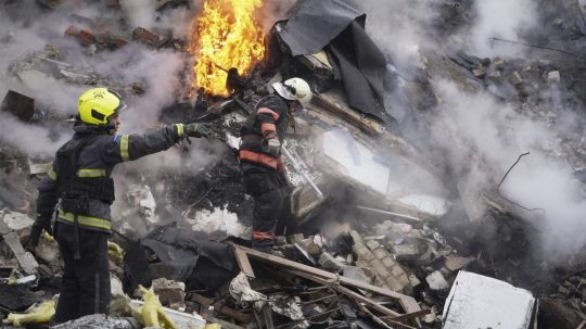 Záchranári pracujú na mieste, kde ruský raketový útok poškodil budovu v Charkove