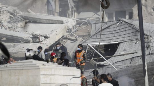 Záchranári pracujú na budove zasiahnutej leteckým útokom v Damasku.