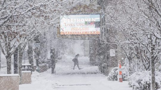 Muž kráča po chodníku počas hustého sneženia v meste Cedar Rapids, americkom štáte Iowa.