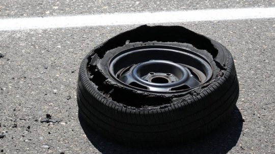 Ilustračná snímka prasknutej pneumatiky na ceste.