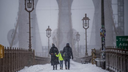 ľudia na zasneženom moste