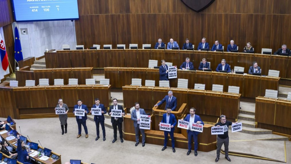 Na snímke v pozadí elektronická tabuľa a opoziční poslanci s transparentami počas hlasovania na 9. schôdzi Národnej rady SR v Bratislave 8. februára 2024.