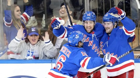 Hráči New York Rangers oslavujú víťazný gól počas predĺženia zápasu hokejovej NHL proti Coloradu Avalanche.
