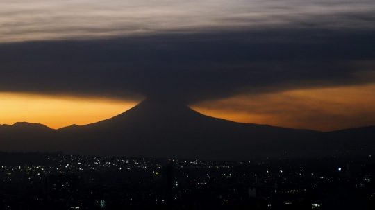 Na snímke sopka Popocatépetl chŕli veľký oblak popola počas východu Slnka.