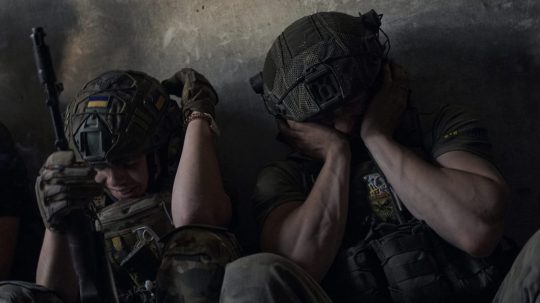 Archívna snímka: Ukrajinskí vojaci si zakrývajú uši, aby ich chránili pred zvukmi ruskej paľby.