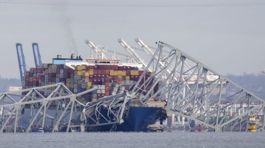 Uviaznutá nákladná loď pod časťou konštrukcie spadnutého mosta.