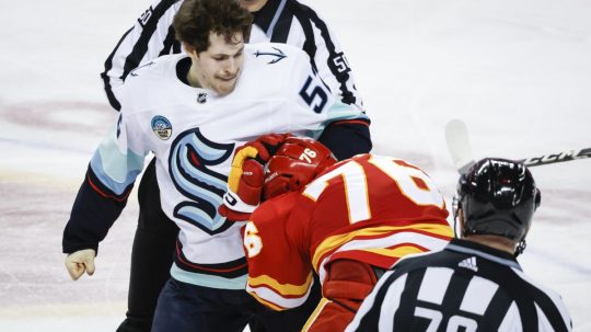 Na snímke druhý zdola slovenský útočník Calgary Martin Pospíšil, nad ním útočník Seattlu Tye Kartye počas bitky v zápase hokejovej NHL.