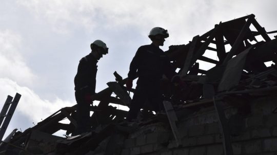 Záchranári odstraňujú trosky zničených domov po útoku ruského dronu na obytnú štvrť v Záporoží 28. marca 2024.