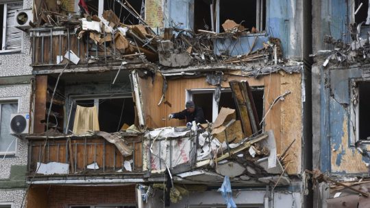 Ľudia odstraňujú trosky zo svojich bytoch na mieste ruského leteckého útoku v Záporoží.