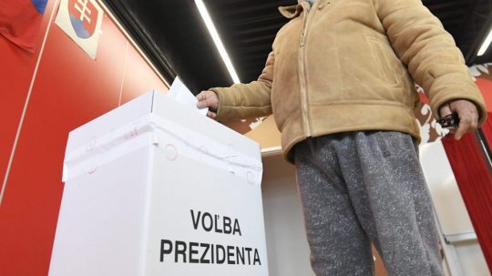 Volič vhadzuje obálku s hlasovacím lístkom do volebnej schránky.