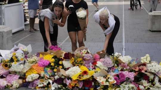 Ženy kladú kvety blízkosti miesta činu na v Sydney.