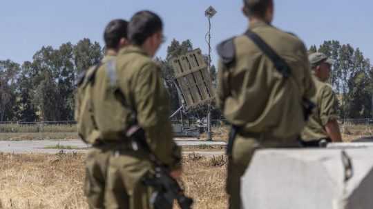 Izraelskí vojaci stoja pri protiraketovom systéme.