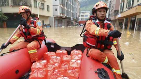 Na snímke čínski záchranári počas záplav.