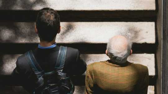 Na snímke mladí a starší muž kráčajú po schodoch.