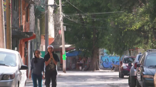 Snímka z Mexika, dve osoby kráčajú po ulici.