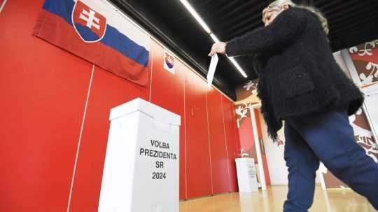 Volička vhadzuje obálku s hlasovacím lístkom do volebnej urny.