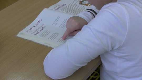 Na snímke žiačka číta z učebnice