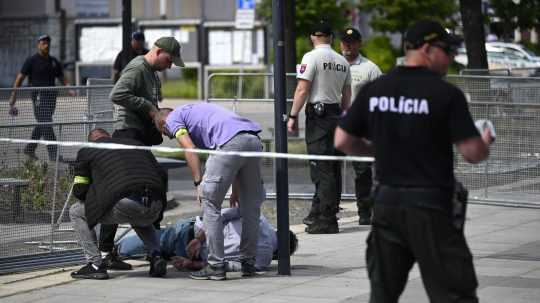 Na snímke policajti zatýkajú muža po streľbe na predsedu vlády Roberta Fica na výjazdovom rokovaní vlády v Handlovej.