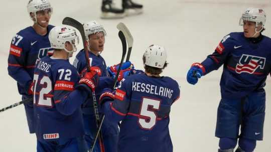 Americký hokejista Brady Tkachuk sa raduje z gólu so spoluhráčmi.