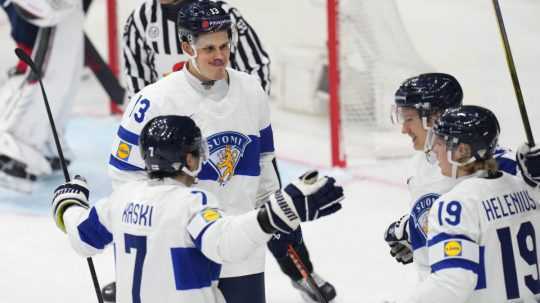 Na snímke fínski hokejisti oslavujú gól.