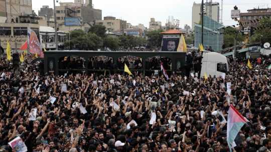 Na snímke davy ľudí počas pohrebu iránskeho prezidenta.