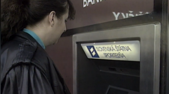 Žena si vyťahuje peniaze v bankomatu.