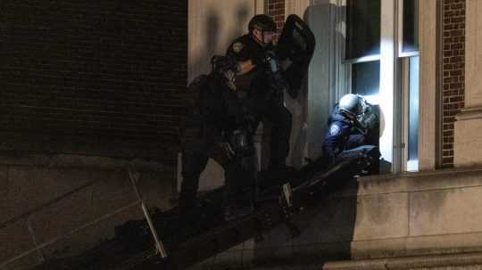 policajti lezú cez okno