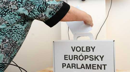 Strašia osoba hádže svoj hlas do urny pri eurovoľbách.