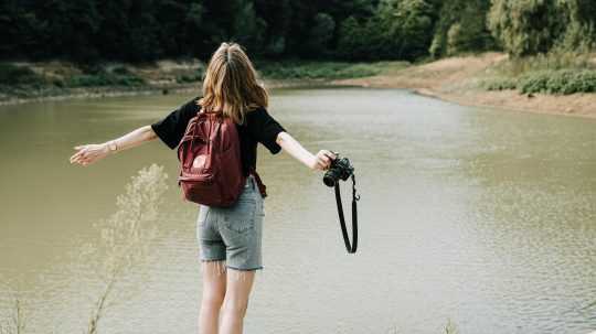Na snímke turistka pri jazere s fotoaparátom.