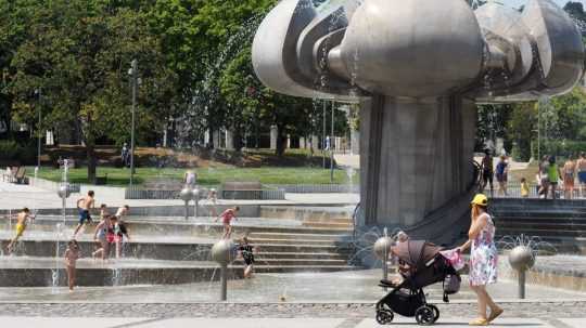 Deti sa hrajú v ikonickej fontáne počas horúčav na Námestí slobody v Bratislave.