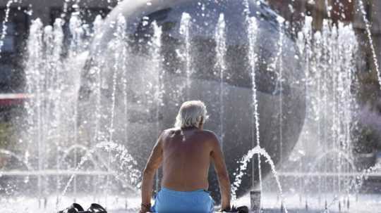 Muž sa ochladzuje vo fontáne pred Prezidentským palácom.