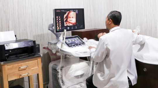 Lekár robí vyšetrenie ultrazvukom tehotnej žene.
