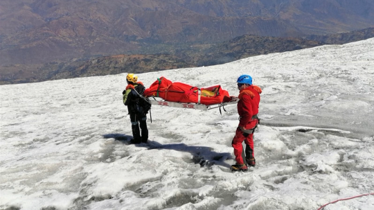 Horskí záchranári nesú telo amerického horolezca.