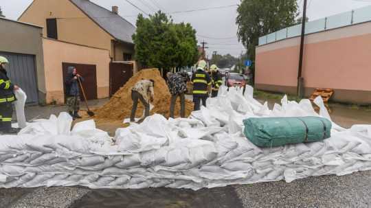 Hasiči stavajú hrádzu z vriec s pieskom v Devínskej Novej Vsi.