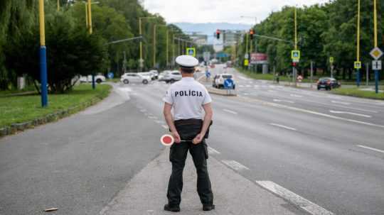 Policajt čaká na vozidlo počas dopravno-preventívnej akcie.