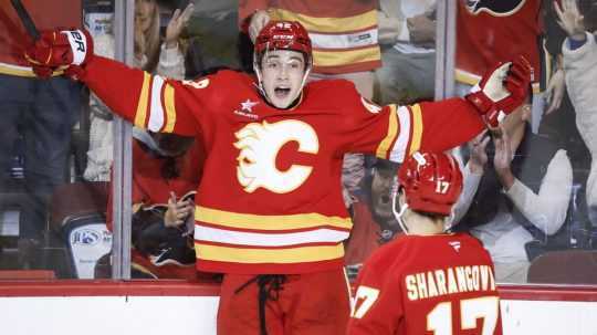 Slovenský hokejista Samuel Honzek (vľavo) a Jegor Šarangovič z Calgary Flames sa radujú z gólu počas prípravného zápasu na novú sezónu zámorskej NHL Calgary Flames - Seattle Kraken.