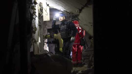 Na archívnej snímke záchranári zasahujú v poškodenej budove v Charkove.