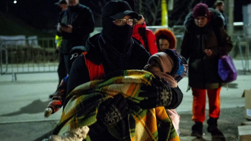 Dobrovoľník odnáša dieťa utečencov z Ukrajiny do stanu na slovensko-ukrajinskom hraničnom priechode.