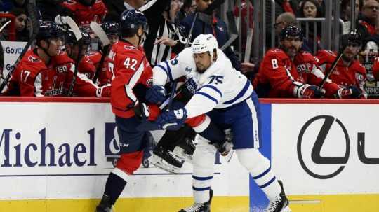 Slovenský hokejista v drese Washingtonu Capitals Martin Fehérváry (vľavo) a hráč Toronta Maple Leafs Ryan Reaves.