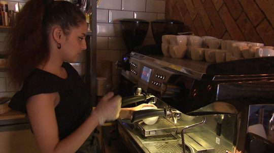 Na snímke študentka-čašníčka pripravuje kávu.